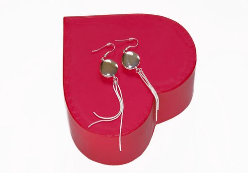 silver earrings gift over red heart box isolated