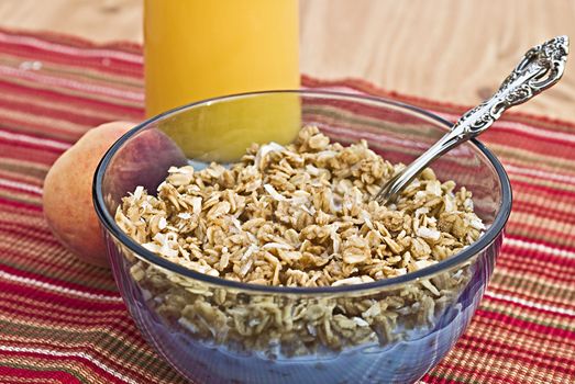 Bowl of granola with a peach and juice


