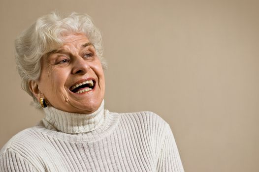 Senior lady portrait, laughing, with copy space.