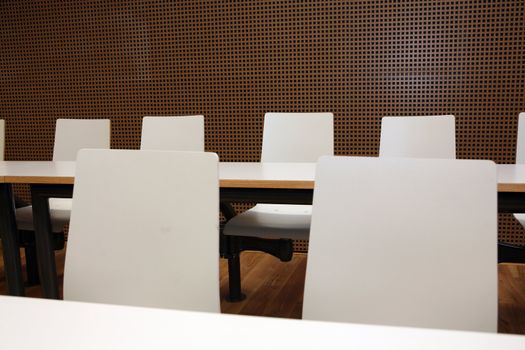 Inside of boardroom with white seats and tables