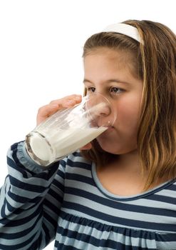 A young female child drinking a glass of milk, isolated against a white background