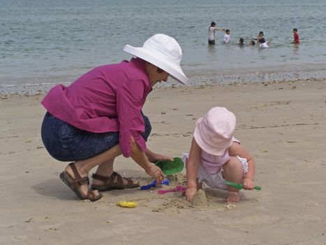 Grandmother and grandaughter play on the beach