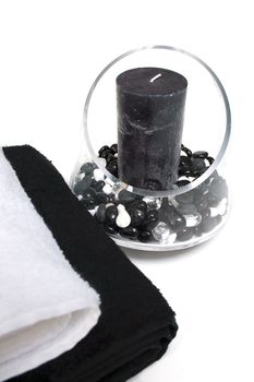 Towels and candel inside a glass vase