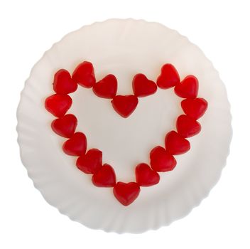 heart shaped fruit jellies on plate, isolated on white