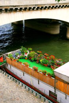 Charming houseboat with flowers docked on Seine in Paris, France