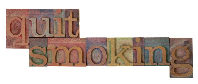 quit smoking words in vintage wooden letterpress type blocks, stained by color ink, isolated on white
