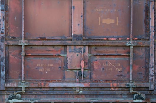 Red rusted old railroad car door and latch