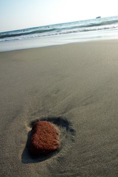 Red stone in the sand after ebb in Puerto Escondido, Mexico