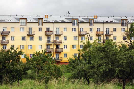 Clouds over yellow and orange prefab hous