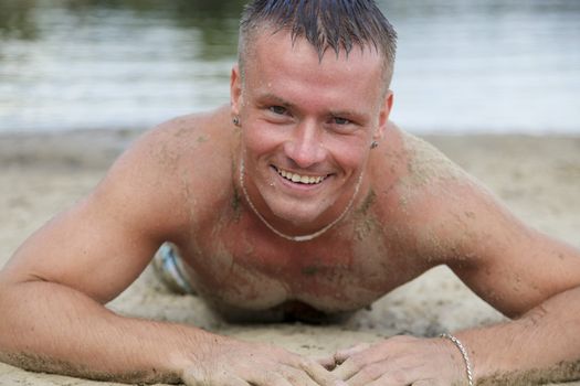 Cheerful Good Looking Man Having Fun In The Sand While Sunbathing