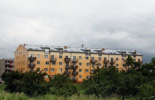 Clouds over yellow and orange prefab hous