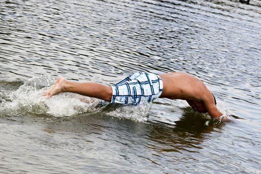 Dynamic Jump Of A Muscular Young Man Into The Water 
