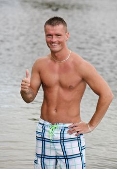 Handsome Athletic Guy Showing The Okay Sign Near Water