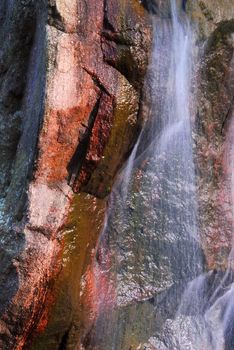Water flowing down over big granite rock