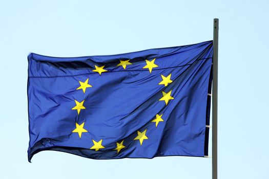 Flag of European Union blowing on blue sky