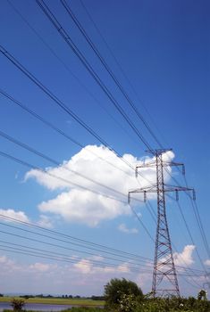 Electric pylons and wires on the cloudy sky