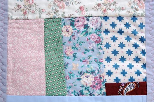 a portion of a crazy quilt with various floral and print fabrics
