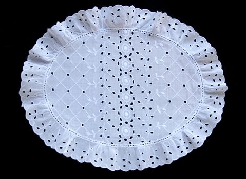 eyelet fabric with a ruffled edge isolated on black