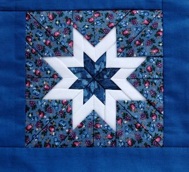 quilted star in white with colorful fabrics and a blue border