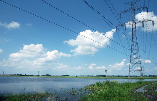 Electric pylons and wires on the cloudy sky