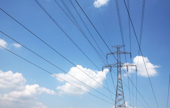 Electric pylons and wires on the cloudy sky