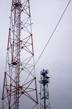 Two modern communication towers on overcast day