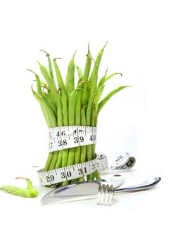 Unwashed green beans with cord and utensils on white