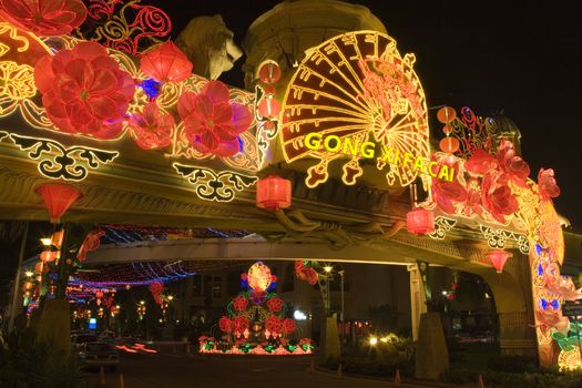 Night image of a street arch decorated with lanterns and lights during Chinese New Year in Malaysia.