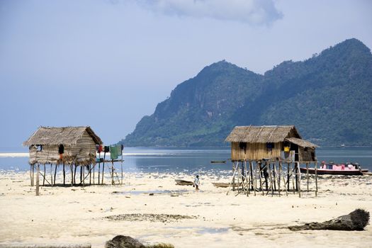 Image of island native huts on stilts and a house boat.