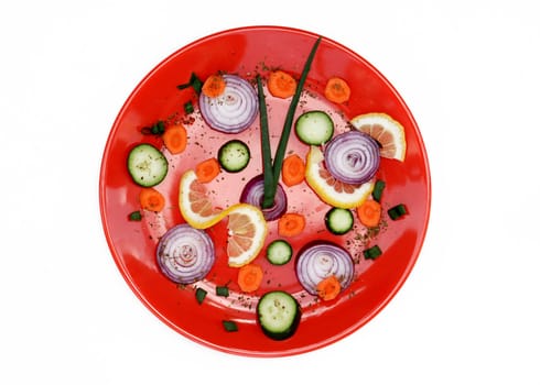 red plate with cut vegetables isolated over white