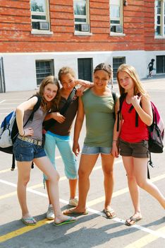 Portrait of a group of young smiling school girls in schoolyard