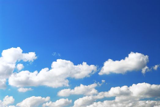 Background of deep blue sky with white fluffy clouds at the bottom