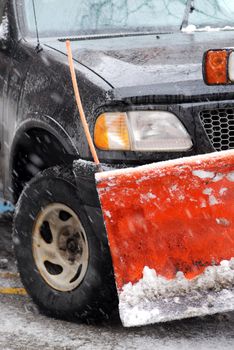 Snow plow truck on a road during a snowstorm