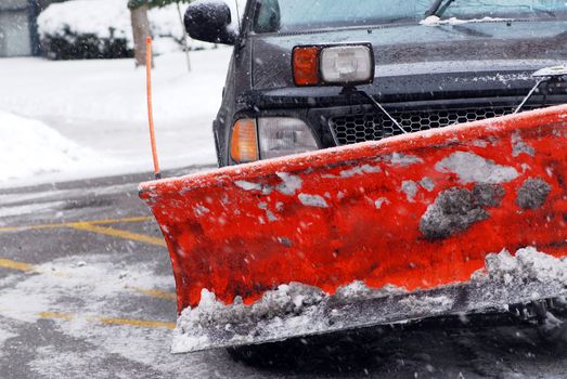 Snow plow truck on a road during a snowstorm