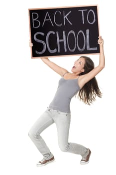 Back to school / university / college. Excited university student holding chalkboard saying back to school. Young female model.