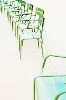 Parisian metallic chairs in the city park. Photo with tilt-shift lens