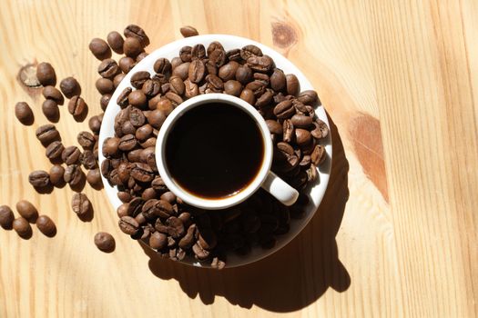 Coffee cup and coffee beans on wooden background