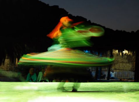 traditional egyptian dancer spinning around in illuminated skirts at night