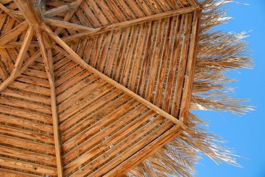 straw wooden sunshade texture over blue sky in resort