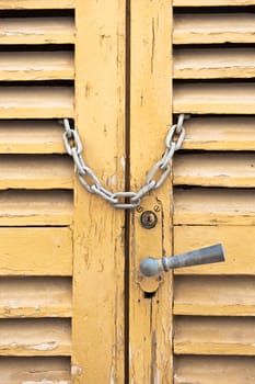 Old wooden door locked with a chain 