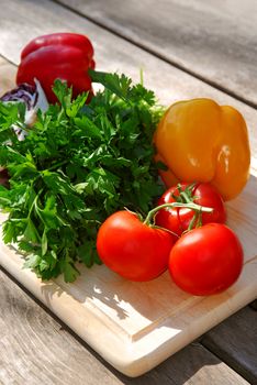 Assorted fresh vegetables on cutting board on rustic table