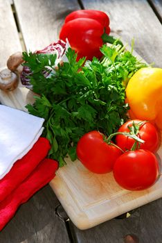 Assorted fresh vegetables on cutting board on rustic table