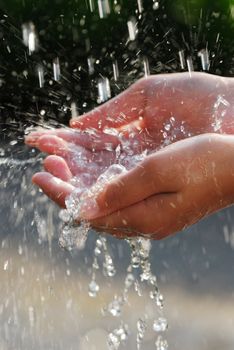 Hands catching clean falling water close up. Environmental concept.
