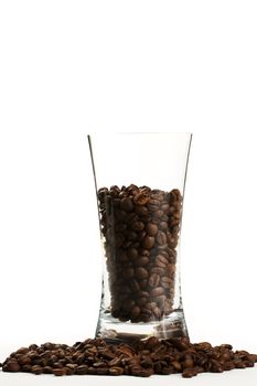 some coffee beans in a glass surrounded by coffee beans