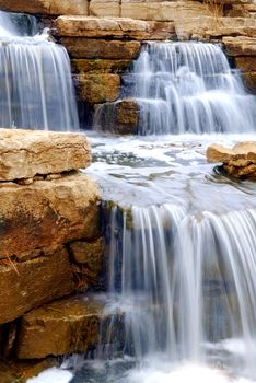 Beautiful cascading waterfall over natural rocks, landscaping element