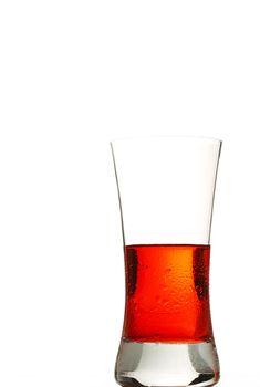 a glass filled with a cold red drink on white background