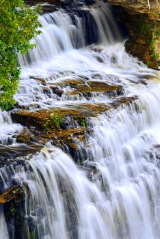Beautiful cascading waterfall flowring over natural rock formation