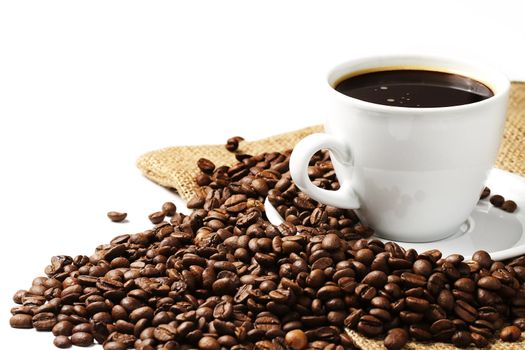 a coffee cup filled with coffee and beans with jute on white background