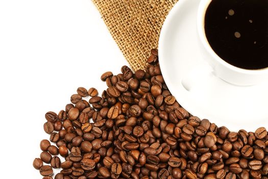 a coffee cup from top filled with coffee and beans with jute on white background