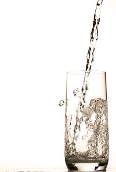 fresh water pouring in glass on white background